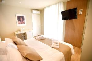 a hotel room with two beds and a flat screen tv at Nina B&B in Reggio di Calabria