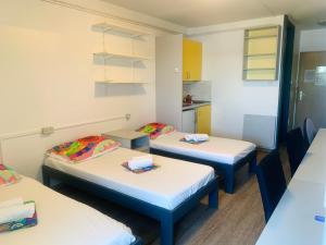 um quarto com três camas e uma cozinha em ŠD Portorož Hostel Korotan em Portorož