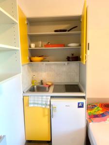 uma pequena cozinha com um lavatório e um frigorífico em ŠD Portorož Hostel Korotan em Portorož