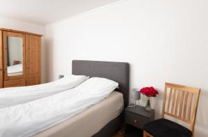 a bedroom with a bed with white sheets and a mirror at Apt 102 - Andenes Whale Safari Apartments in Andenes