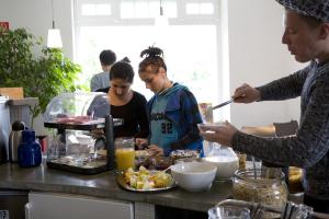 um grupo de pessoas à volta de uma mesa a preparar comida em Jugendgästehaus des CVJM Berlin-Kaulsdorf em Berlim