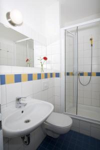 uma casa de banho com um lavatório, um WC e um chuveiro em Jugendgästehaus des CVJM Berlin-Kaulsdorf em Berlim