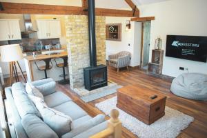 a living room with a couch and a fireplace at Cheesemans Farm Stables in Manston