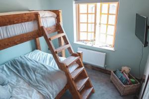 1 dormitorio con litera y escalera en Cheesemans Farm Stables en Manston