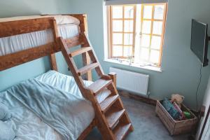 a bedroom with a bunk bed with a ladder at Cheesemans Farm Stables in Manston