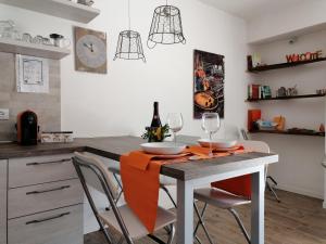 a kitchen with a table with chairs and a clock at Appartamento Sant'Anna I in Salò +31 photos