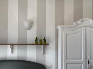 a room with striped walls and a shelf with potted plants at Residenza La Pianca in Musso