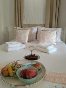 a tray of fruit and vegetables on a bed at Golden Vali House in Kinira