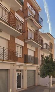 un immeuble d'appartements avec balcon et deux portes de garage dans l'établissement Apartamento Can CALET con PARKING en Sant Antoni de Calonge, à Calonge