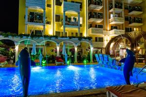a pool in a hotel with dolphins in the water at Sweet Homes Apartments in Sunny Beach