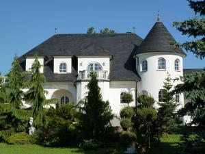 une grande maison blanche avec un toit noir dans l'établissement Gästehaus Villa Casamia, à Schmalkalden