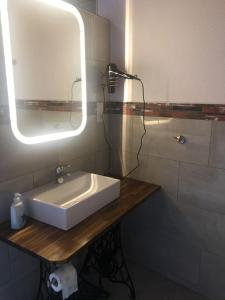 a bathroom with a white sink and a mirror at deinFerienhaus Scheliga „Midi“ in Bad Sobernheim