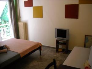 Habitación pequeña con cama y TV. en Kalamata home, City centre en Kalamata