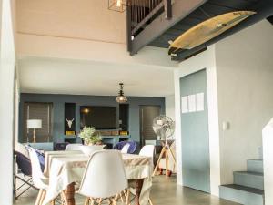 une salle à manger avec une table et des chaises ainsi qu'une planche de surf murale dans l'établissement Weskus Beskus, à Velddrif