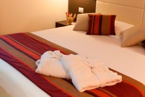 a hotel room with a bed, towels, and pillows at HB Aosta Hotel & Balcony SPA in Aosta