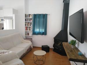 a living room with a couch and a flat screen tv at Alojamiento rural El Yate in Montefrío