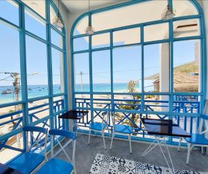 um quarto com cadeiras azuis e vista para o oceano em Chai Village Hotel em Quy Nhon
