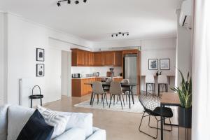 a living room and kitchen with a couch and a table at Superb & Comfy 2BD Apartment in Marousi by UPSTREET in Athens