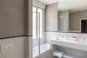 a white bathroom with a sink and a mirror at Golf Hôtel in Brides-les-Bains