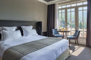 a hotel room with a bed and a table with chairs at Golf Hôtel in Brides-les-Bains