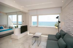 a living room with a couch and a bed and a television at Les Palmiers Sunorama Beach Apartments in Larnaca