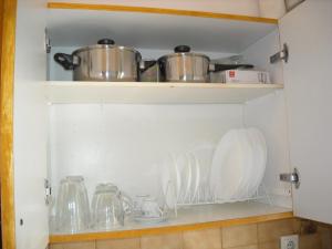 estante de cocina con platos, ollas y sartenes en Kalamata home, City centre en Kalamata