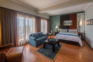 ダル・エス・サラームにあるSea Cliff Hotelのベッドと椅子付きのホテルルーム