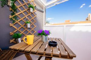 une table en bois sur un balcon avec des plantes en pot dans l'établissement Apartment 63 - 3, à Zagreb