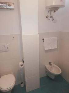 La salle de bains blanche est pourvue de toilettes et d'un lavabo. dans l'établissement I Tre Archi, à Grottaminarda