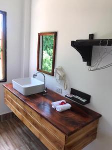 La salle de bains est pourvue d'un lavabo et d'un miroir sur un comptoir en bois. dans l'établissement Nam ou view villa, à Nongkhiaw