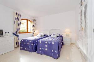 een witte slaapkamer met 2 bedden en een raam bij La Manga Club Resort - Las Palmeras 483 in Atamaría