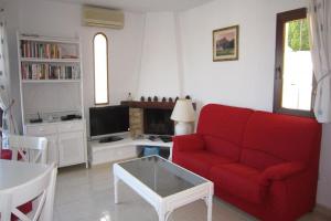 een woonkamer met een rode bank en een tafel bij La Manga Club Resort - Los Molinos 338 in Atamaría