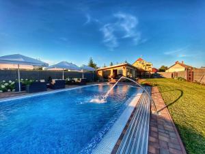 a swimming pool with a water slide in a backyard at Madison Village in Kisvárda
