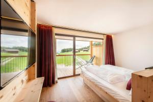a bedroom with a bed and a large window at Hotel Seelaus in Alpe di Siusi