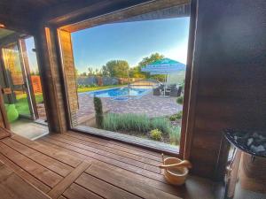 a sliding glass door with a view of a swimming pool at Madison Village in Kisvárda