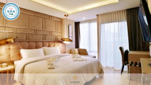 a hotel room with a bed with towels on it at De Prime Rangnam Hotel in Bangkok