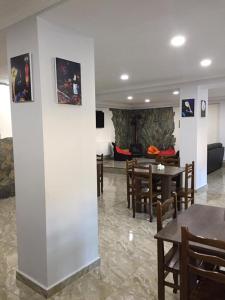 Guesthouse Gera في ميستيا: غرفة بها طاولات وكراسي وغرفة معيشة