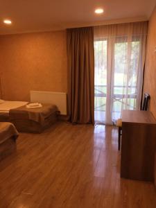 um quarto de hotel com duas camas e uma grande janela em Guesthouse Gera em Mestia