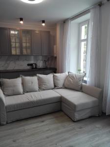 un divano bianco in un soggiorno con finestra di Apartament Maja 2 pokoje stare miasto Gdańsk parking w cenie a Danzica