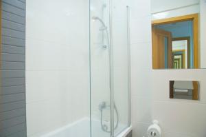 una ducha con puerta de cristal en un baño en Apartament Jawa, en Łódź