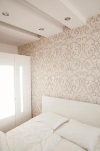 1 dormitorio con cama blanca y pared en Apartament Jawa, en Łódź
