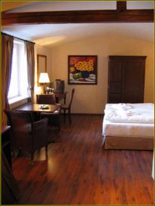 a bedroom with a bed and a desk and a table at Hotel Villa Boddin in Heppenheim an der Bergstrasse