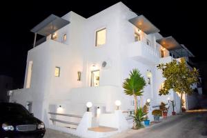 Naxos Enjoy Apartments في ناكسوس تشورا: مبنى ابيض كبير عليه انوار