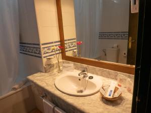 
a bathroom sink with a toothbrush and toothpaste on it at Hotel Flamero in Matalascañas
