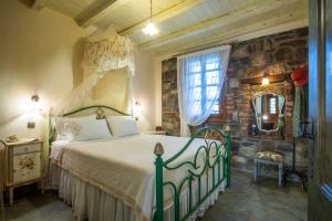 a bedroom with a bed and a stone wall at Ta Petrina in Vourvourou +37 photos
