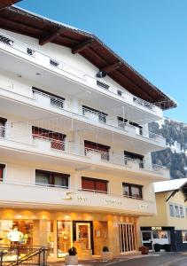 a hotel room with a large white building behind it at Alphotel Garni Salner in Ischgl