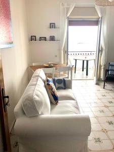- un canapé blanc dans le salon avec une table dans l'établissement VacanzeNaxos - Casa Frontemare, à Giardini Naxos