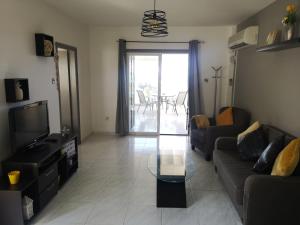 - un salon avec un canapé et une table en verre dans l'établissement Sea View Aparment, à Klorakas