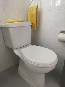 La salle de bains est pourvue de toilettes blanches et d'une serviette jaune. dans l'établissement Sea View Aparment, à Klorakas