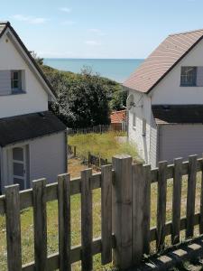 een houten hek voor twee huizen bij Equihen Plage Maison 83 in Équihen-Plage